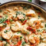Crevettes grillées trempées dans une sauce crémeuse à l’ail